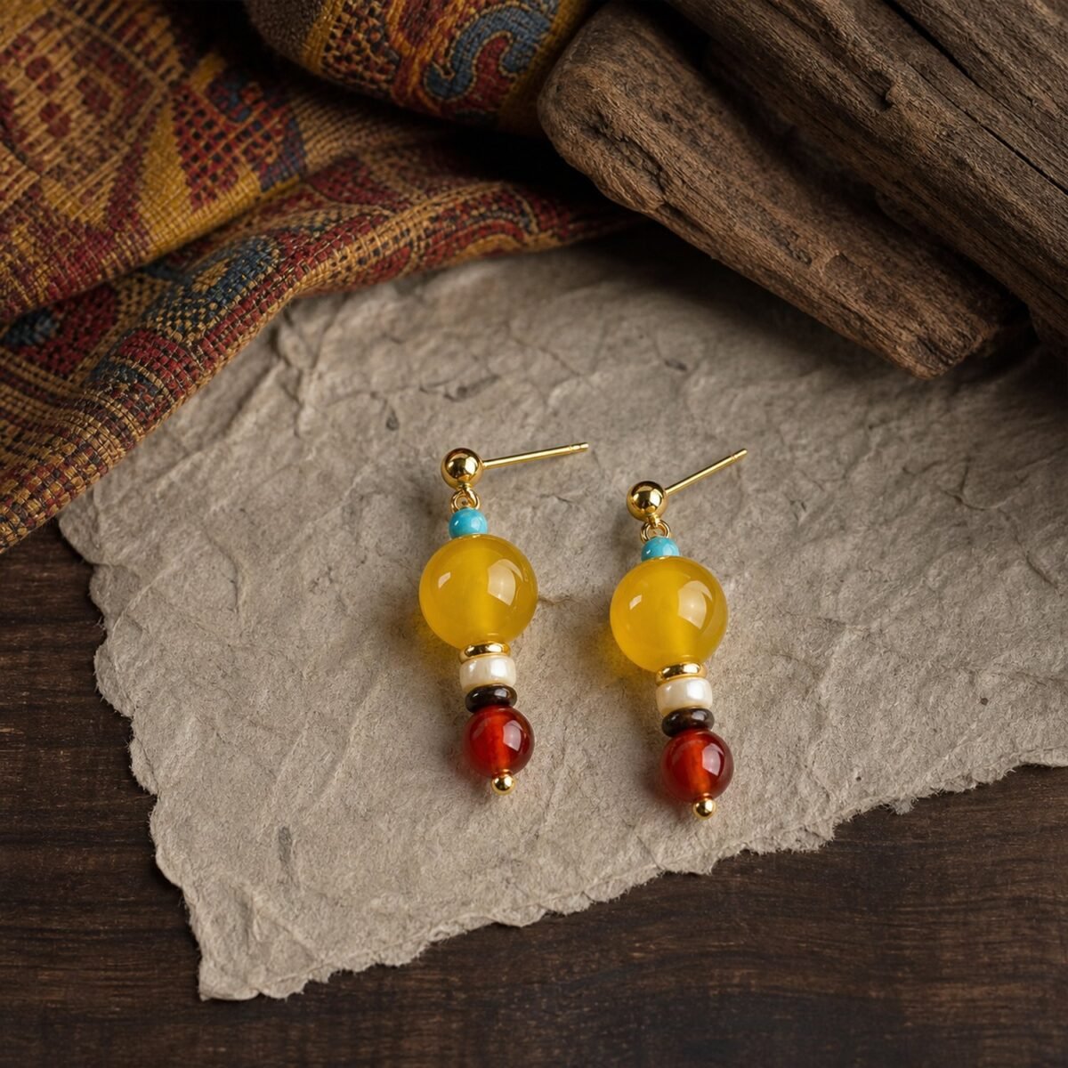 Post Earrings with amber-toned yellow jade, tiger’s-eye detail, red agate, shell, turquoise-colored bead and gold-tone copper