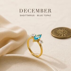 December birthstone ring with blue topaz-colour centre crystal and two clear accent crystals