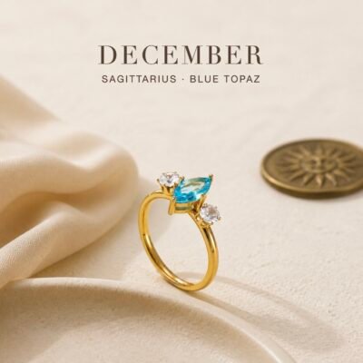 December birthstone ring with blue topaz-colour centre crystal and two clear accent crystals