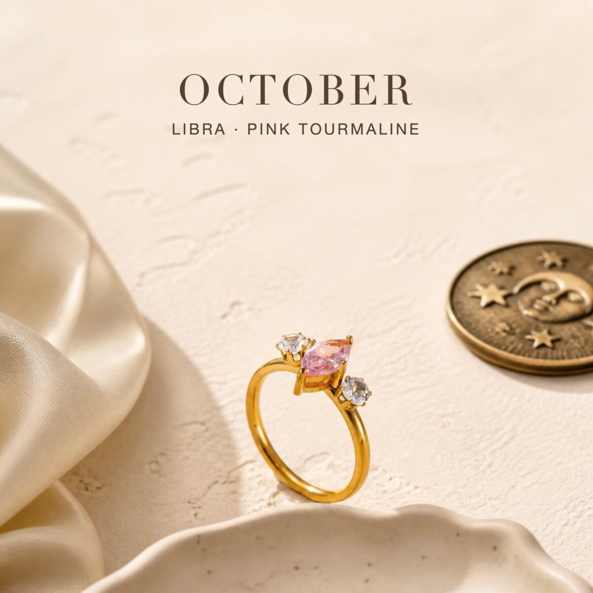 Pink tourmaline ring with a gold-tone marquise trio setting and two clear accent crystals