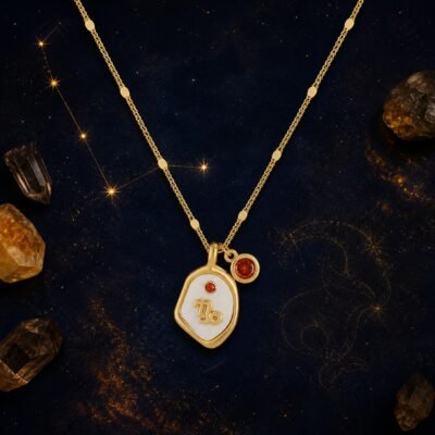 Capricorn Garnet Necklace with pearlescent zodiac medallion raised gold-tone glyph and natural garnet charm.