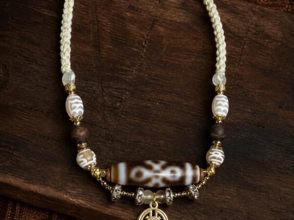 Dzi Charm Necklace with adjustable cord, tassel, and symbolic focal bead