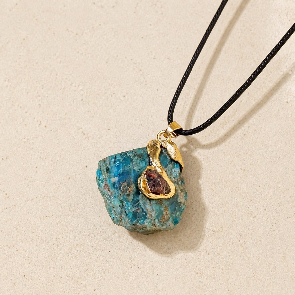 gold-wrapped-raw-crystal-talisman-pendant-collection-blue-apatite-01-main Blue apatite raw crystal pendant with gold-tone wrap and black hand-braided cord