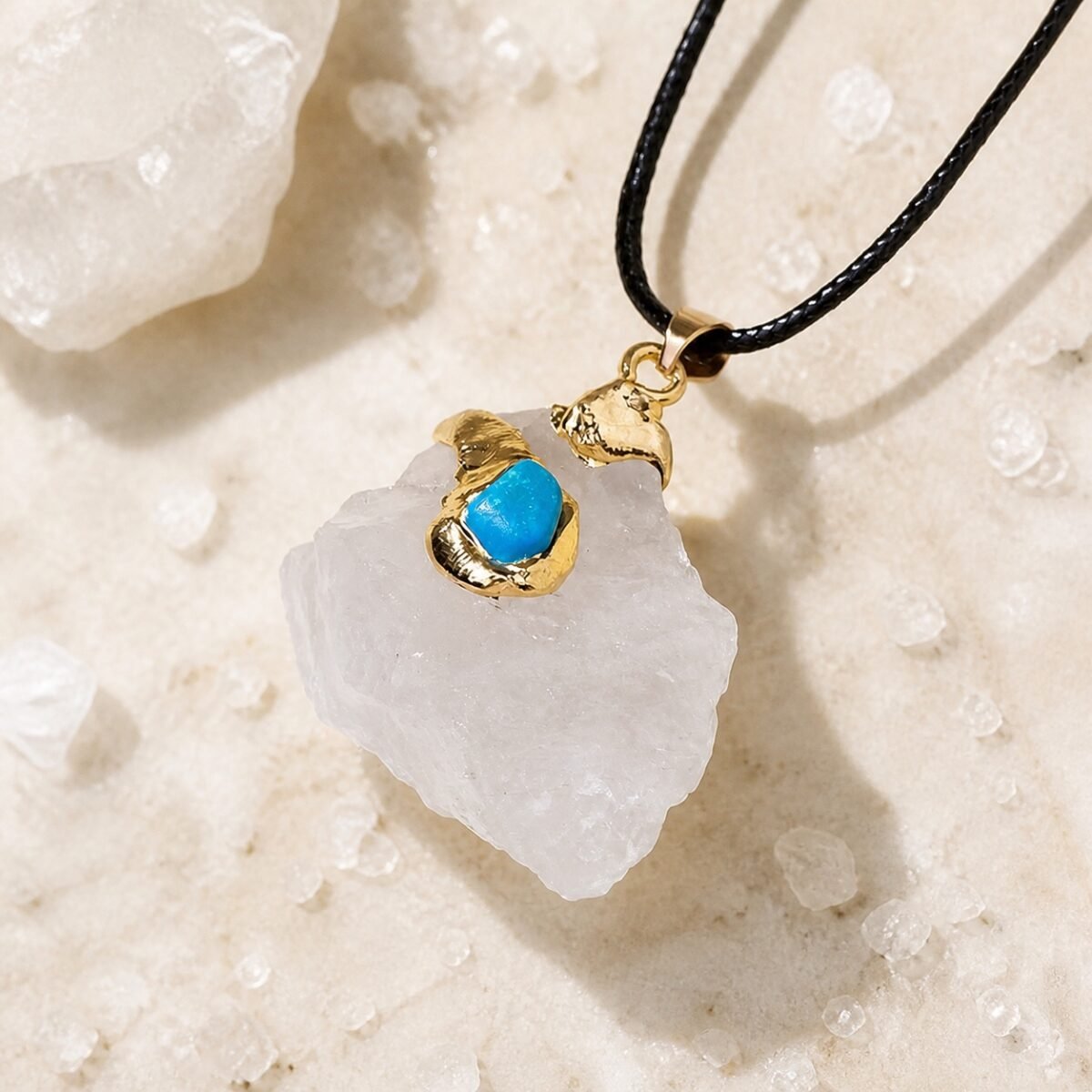 Gold wrapped raw crystal pendant in clear quartz with gold-tone wrap and black leather cord