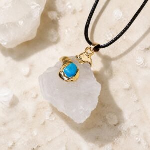 Gold wrapped raw crystal pendant in clear quartz with gold-tone wrap and black leather cord