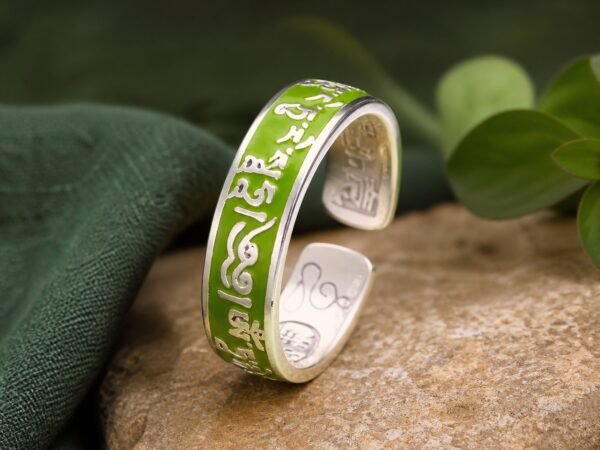 Green Tara mantra ring with raised copper details beneath a colored resin dome