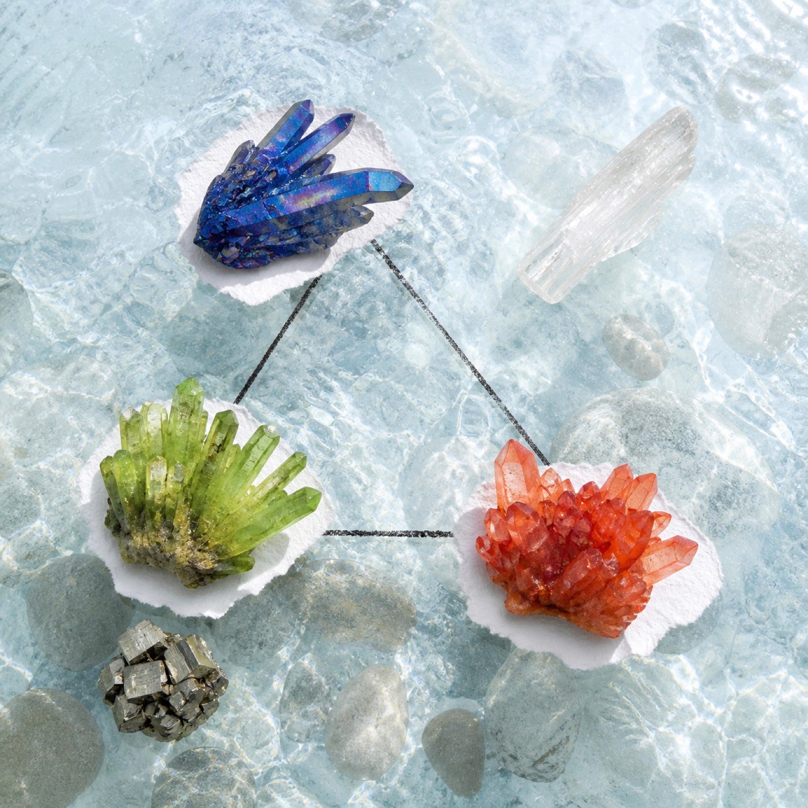 Crystal points and colored stones resting on translucent mountain ice
