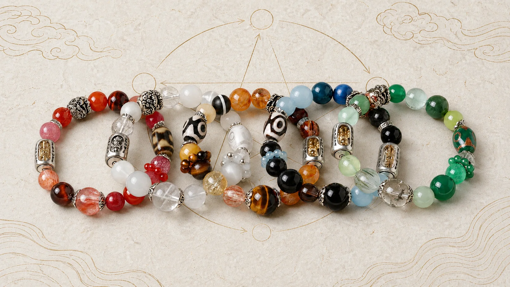 Five overlapping gemstone bracelets in Fire, Metal, Earth, Water and Wood palettes on a pale Five Elements background
