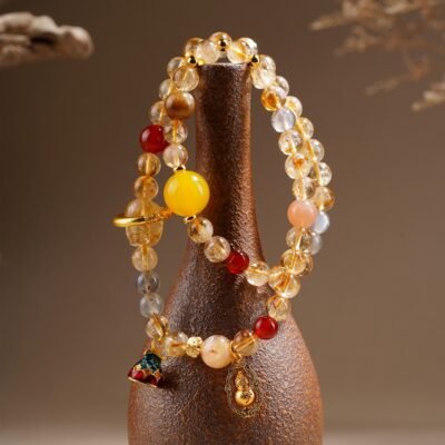 Golden Pixiu Abundance Bracelet worn on the wrist with a carved yellow Pixiu focal bead and warm mixed crystal accents.