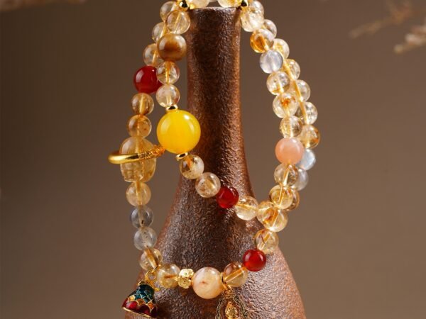 Golden Pixiu Abundance Bracelet worn on the wrist with a carved yellow Pixiu focal bead and warm mixed crystal accents.