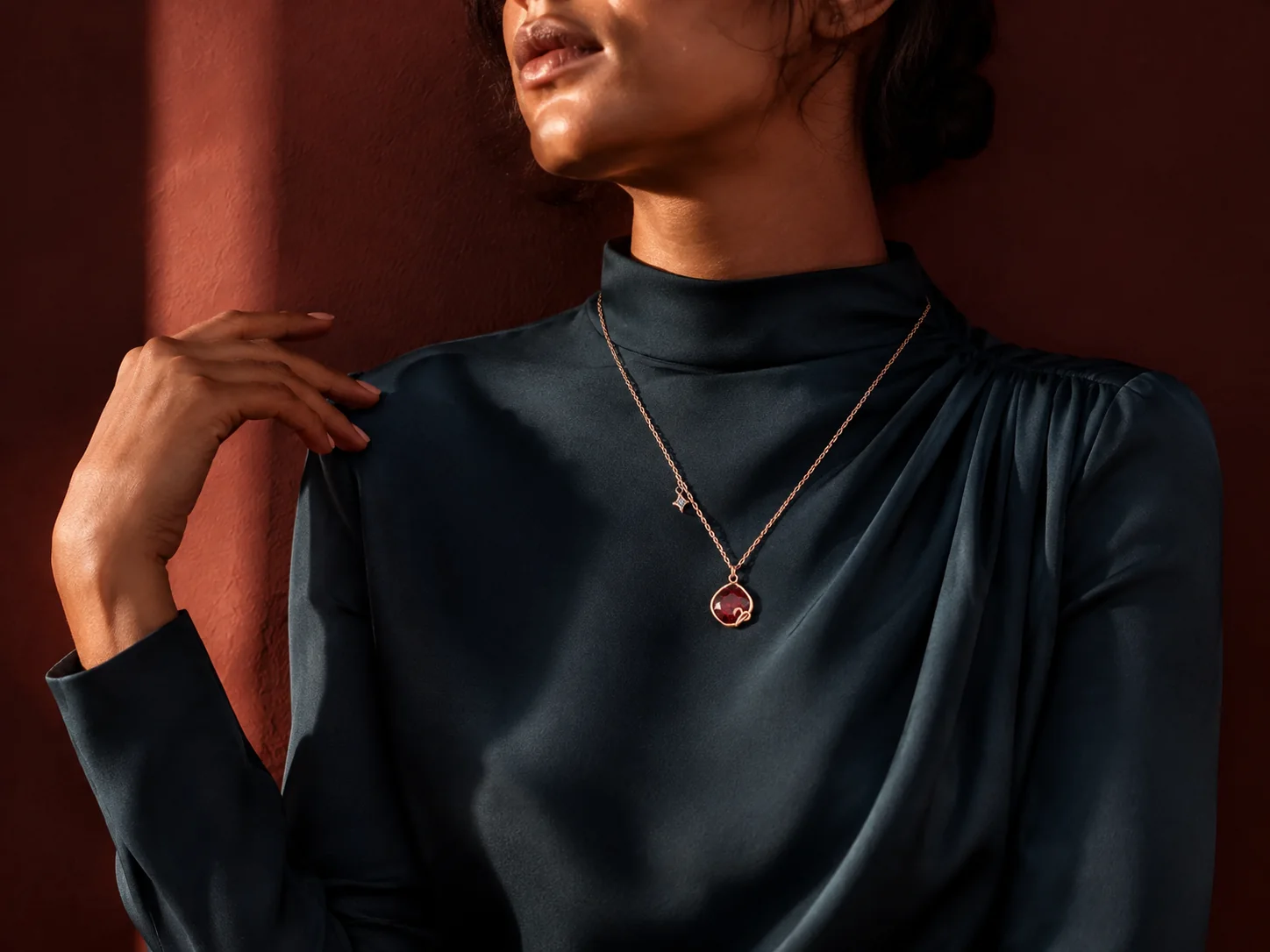 Model wearing a rose-gold red-crystal zodiac necklace