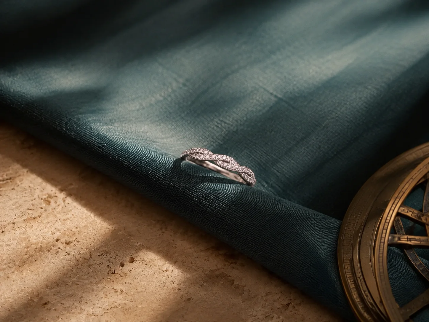 Silver wave pavé birthstone ring on deep teal silk